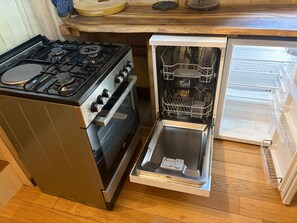 Cozinha compacta com fogão, forno e lava-louças embutidos.
