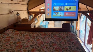 Une pièce comprenant un lit, un bureau et un écran fixé au mur qui affiche l’écran d’accueil.