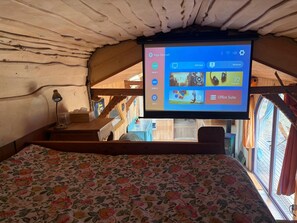 Quarto com cama, escrivaninha e tela fixada exibindo a tela inicial.