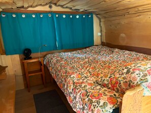 Quarto com cama, escrivaninha e cadeira.