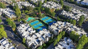 A residential area with multiple apartment buildings, a tennis court, and a parking lot. - Stylish 3BR Woodland Hills with Private Balcony (Los Angeles)