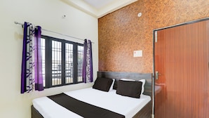 Une chambre à coucher avec un lit, des rideaux, une fenêtre et une porte.