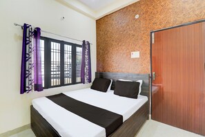 A bedroom with a bed, curtains, a window, and a door. - Super Hotel O Sudhirpur (Varanasi)