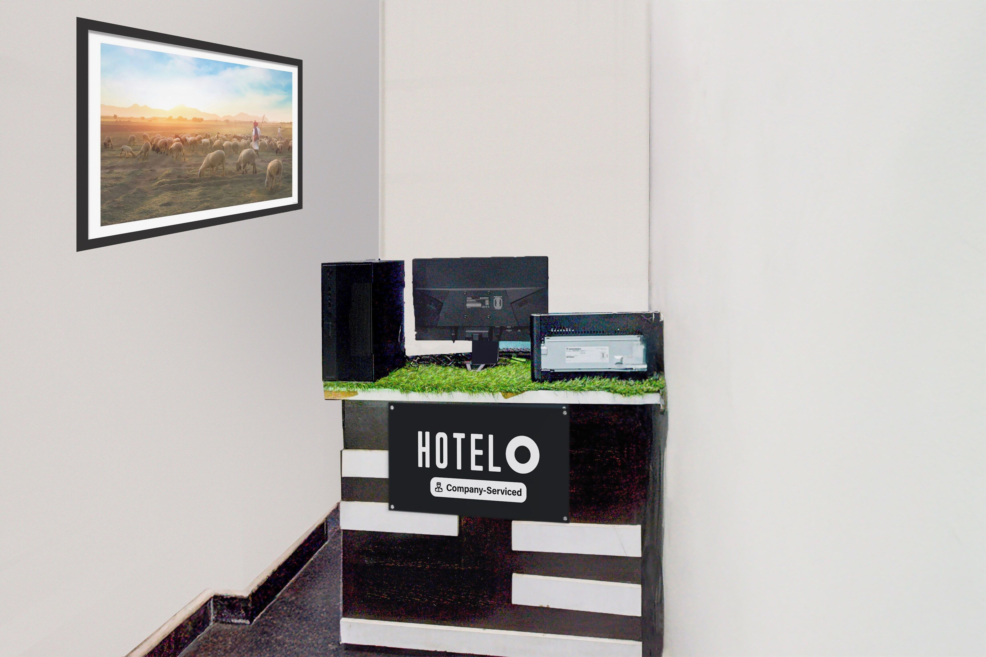 A hotel reception desk with a sign indicating it is company-serviced.