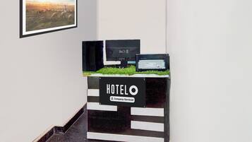 A hotel reception desk with a sign indicating it is company-serviced.