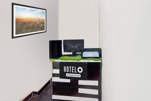 A hotel reception desk with a sign indicating it is company-serviced. - Super Hotel O Malkajgiri (Hyderabad)