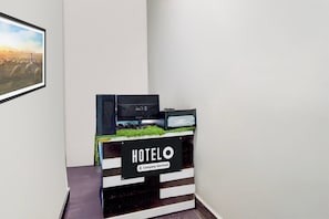 Un mostrador de recepción con un cartel que dice 'HOTELO Company-Serviced' en un pasillo.