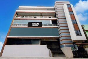 Un hotel de varios pisos con un cartel llamativo que dice 'HOTEL' en la fachada.