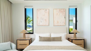 A hotel room with a large bed, two nightstands, a chair, and artwork on the walls. - FORGET-ME-NOT (Blue Mountain Road)