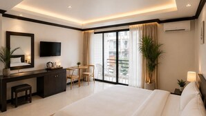 A modern hotel room with a large bed, a desk, a flat-screen TV, and a balcony with a view. - InterCon 3 Bedrooms (Hua Hin)