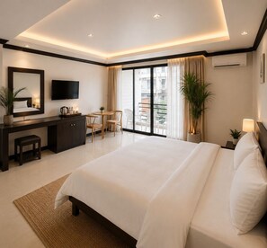 A modern hotel room with a large bed, a desk, a flat-screen TV, and a balcony with a view. - InterCon 3 Bedrooms (Hua Hin)