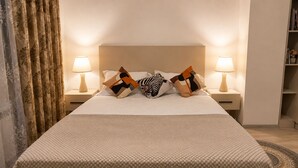 A neatly made bed with a patterned bedspread, two bedside lamps, and decorative pillows. - Apartment Valley of legends mall  (Namangan)