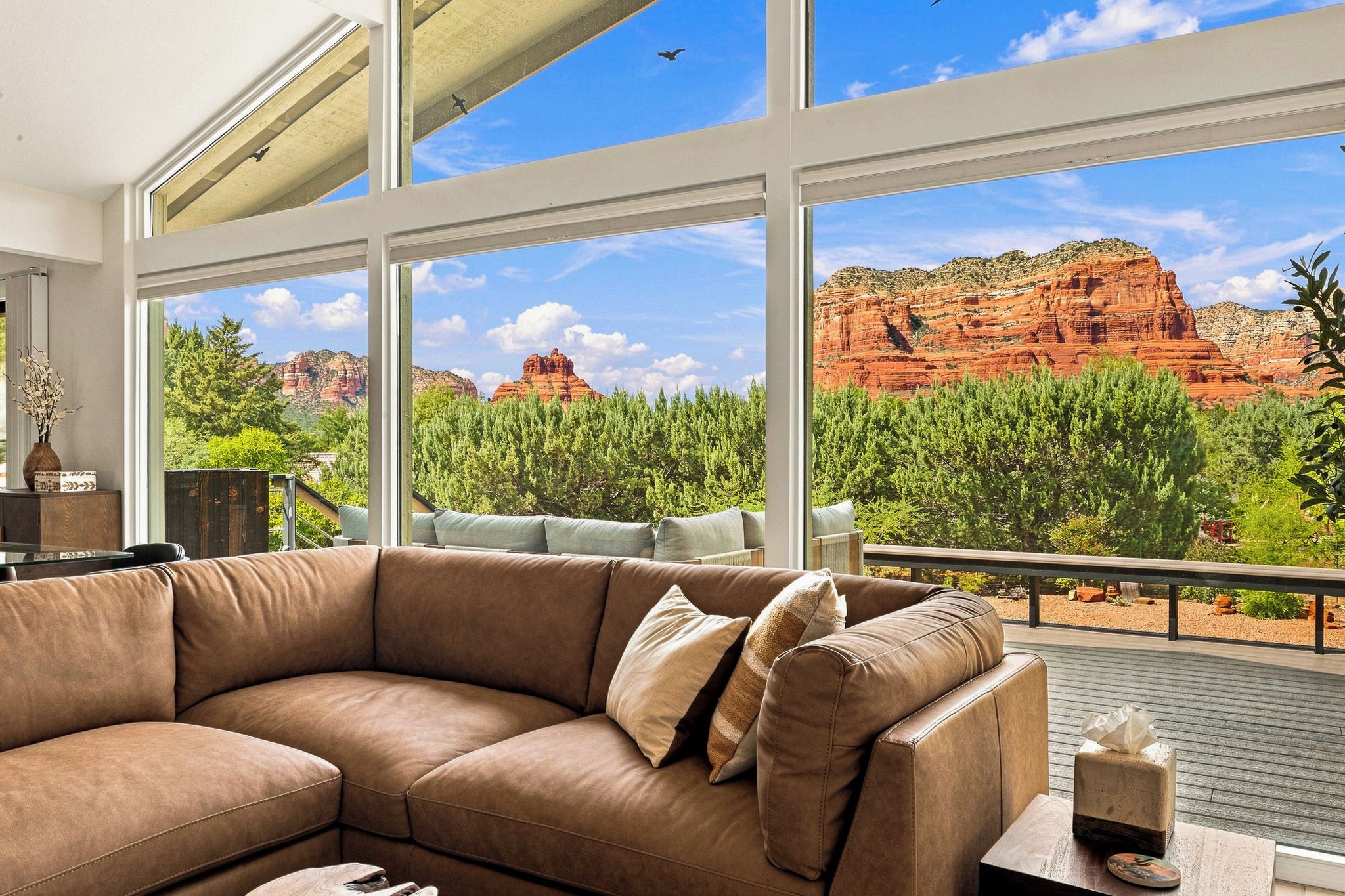A room with a large window overlooking a natural landscape with red rock formations.