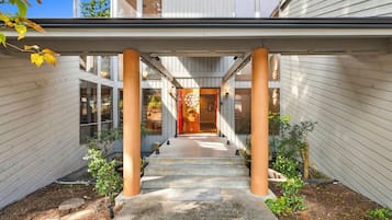 Un bâtiment moderne doté d’une galerie couverte, de grandes fenêtres et d’une porte centrale donnant accès à un espace intérieur.