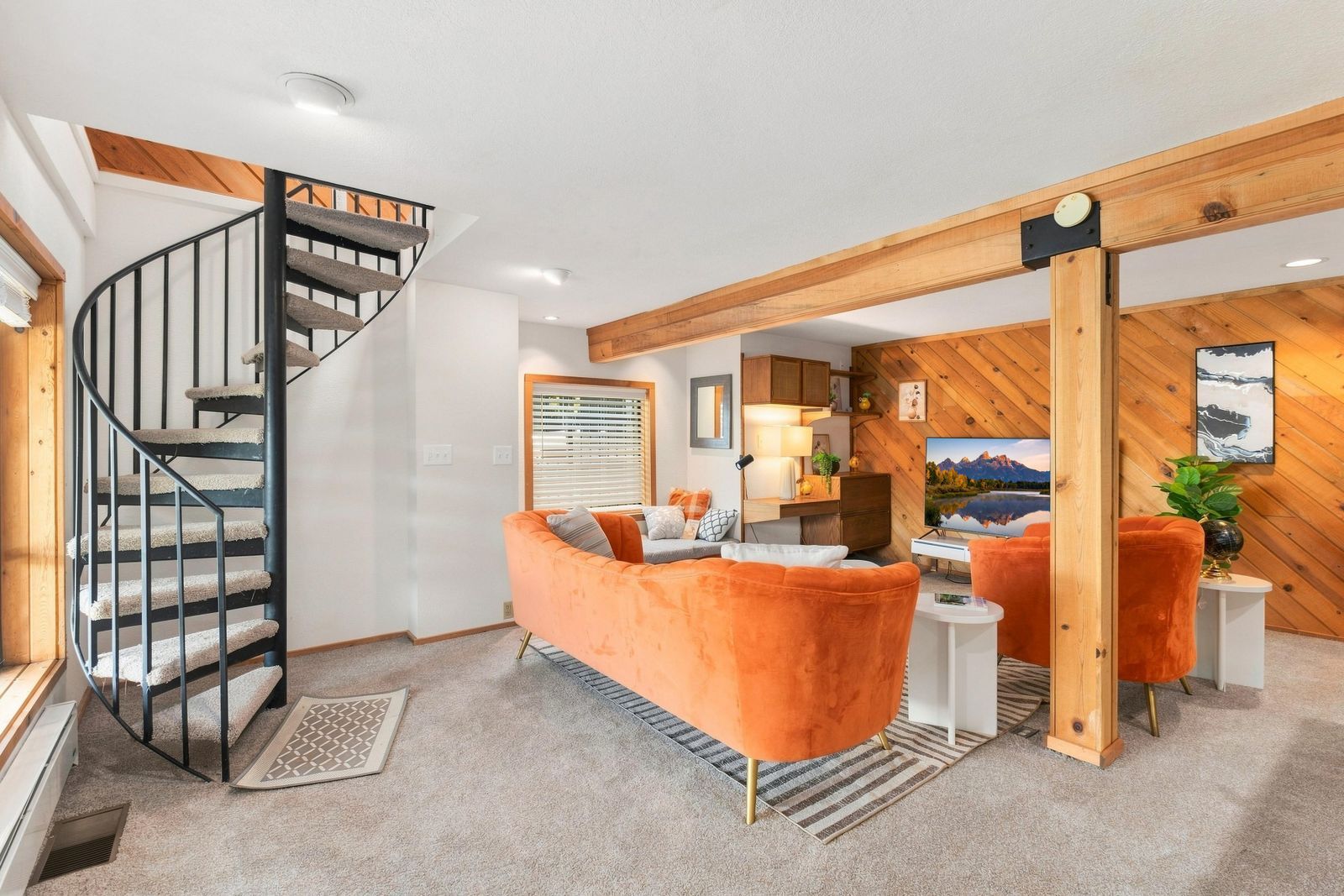 A modern living room with a spiral staircase, a sofa, and a television.