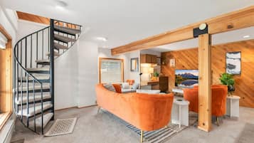A modern living room with a spiral staircase, a sofa, and a television.
