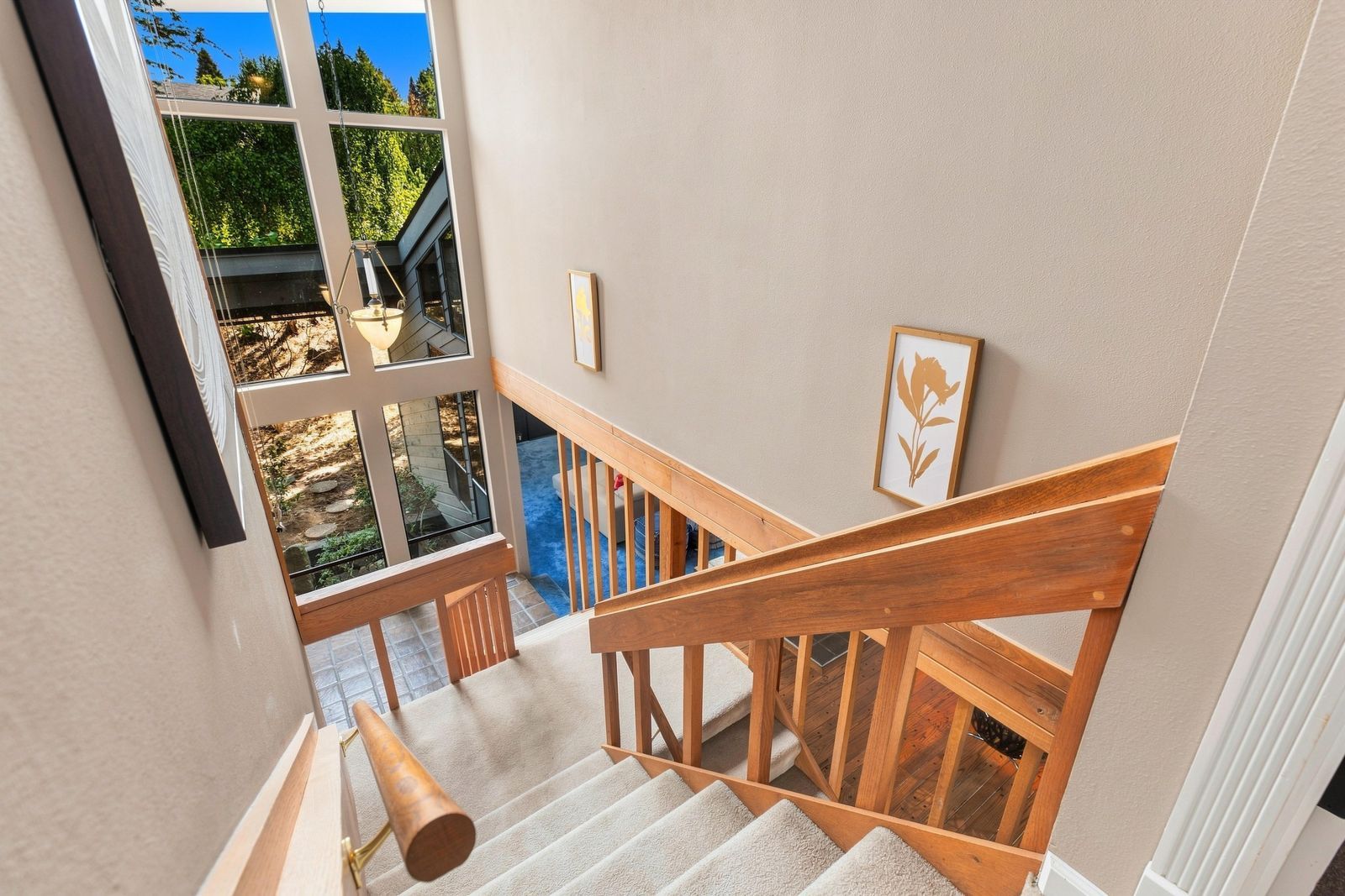 Un escalier avec des rampes en bois menant à un balcon d’où l’on peut admirer la verdure.