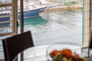 A view of a boat docked at a marina with a table and chairs in the foreground. - Harbourside 1-Bed Apt in Woolloomooloo Wharf (Woolloomooloo)