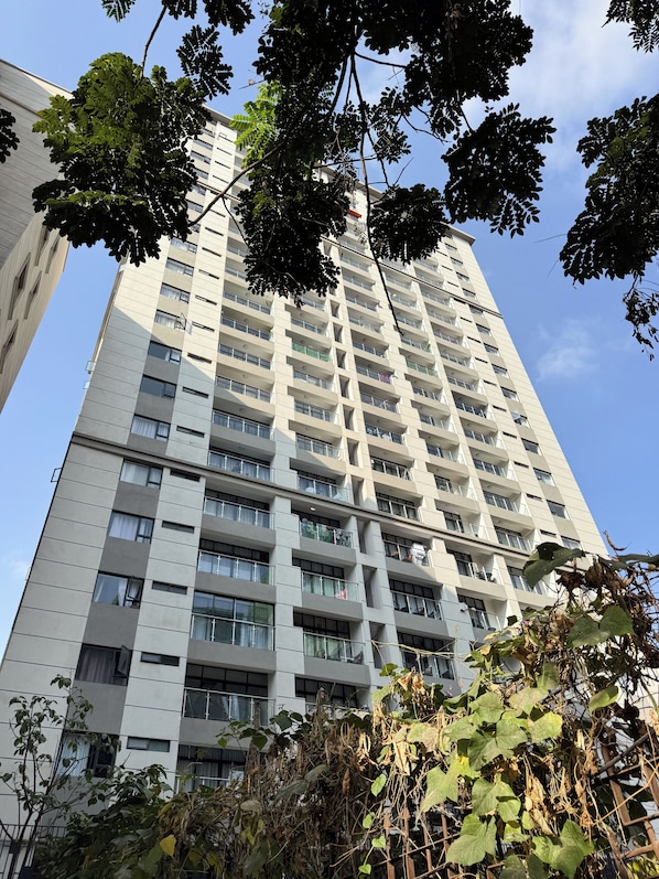 Un immeuble de grande hauteur doté de nombreux balcons, de grandes fenêtres et surplombant un ciel dégagé.