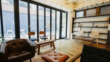 A modern interior with leather furniture, wooden tables, and a bookshelf.