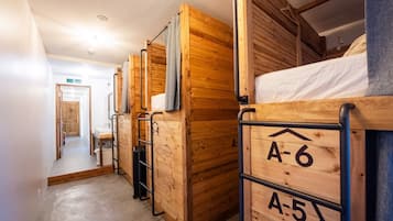 A corridor with bunk beds labeled A-5 and A-6, wooden walls, and a door marked 'B'.