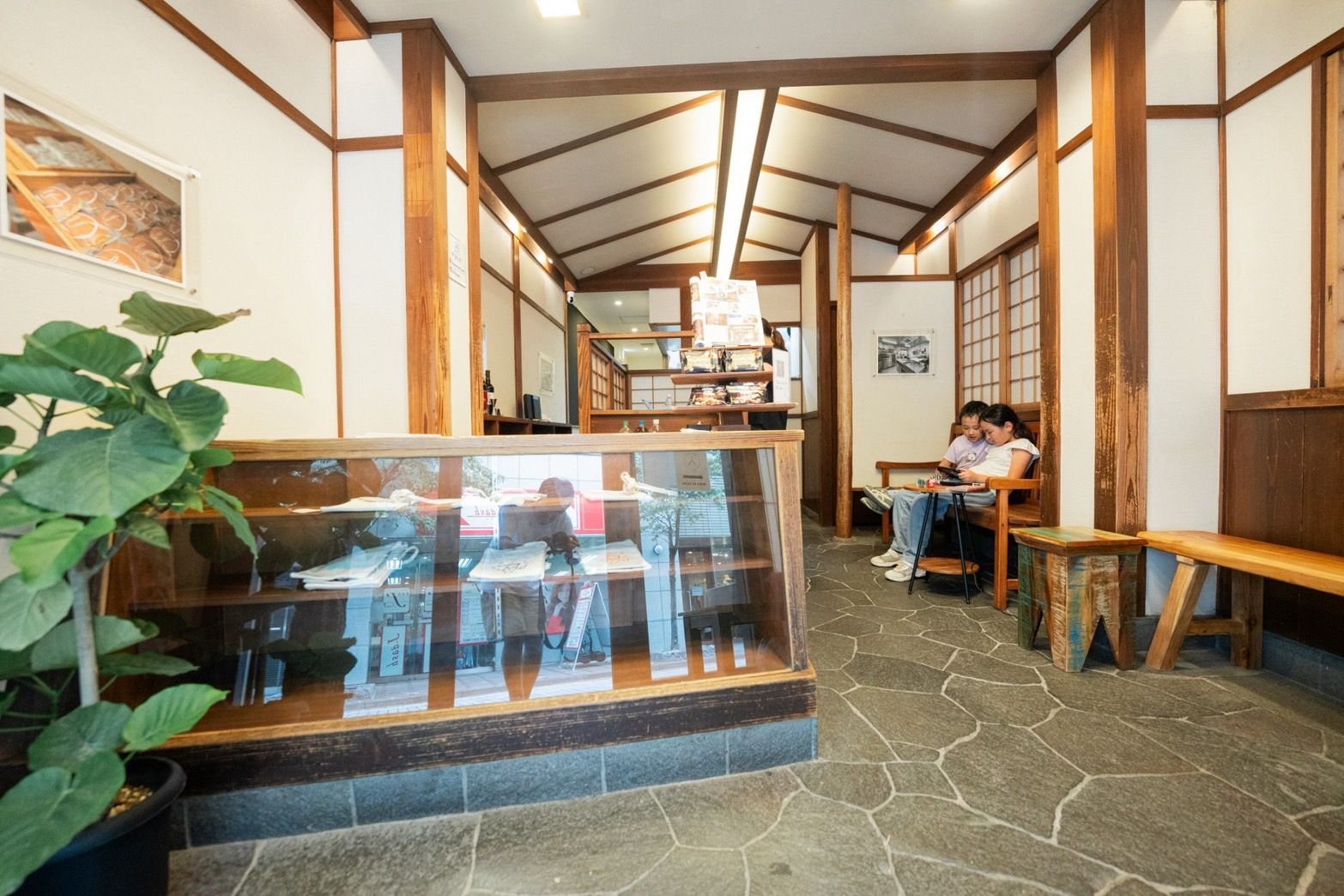A traditional Japanese inn with tatami mat flooring, wooden beams, and a glass display case with items.