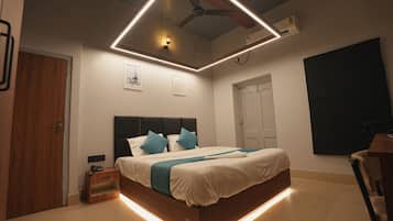 Un dormitorio moderno con cama, mesita de noche y ventilador de techo.