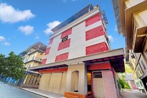 Un hotel con fachada moderna, varios balcones y una entrada destacada.