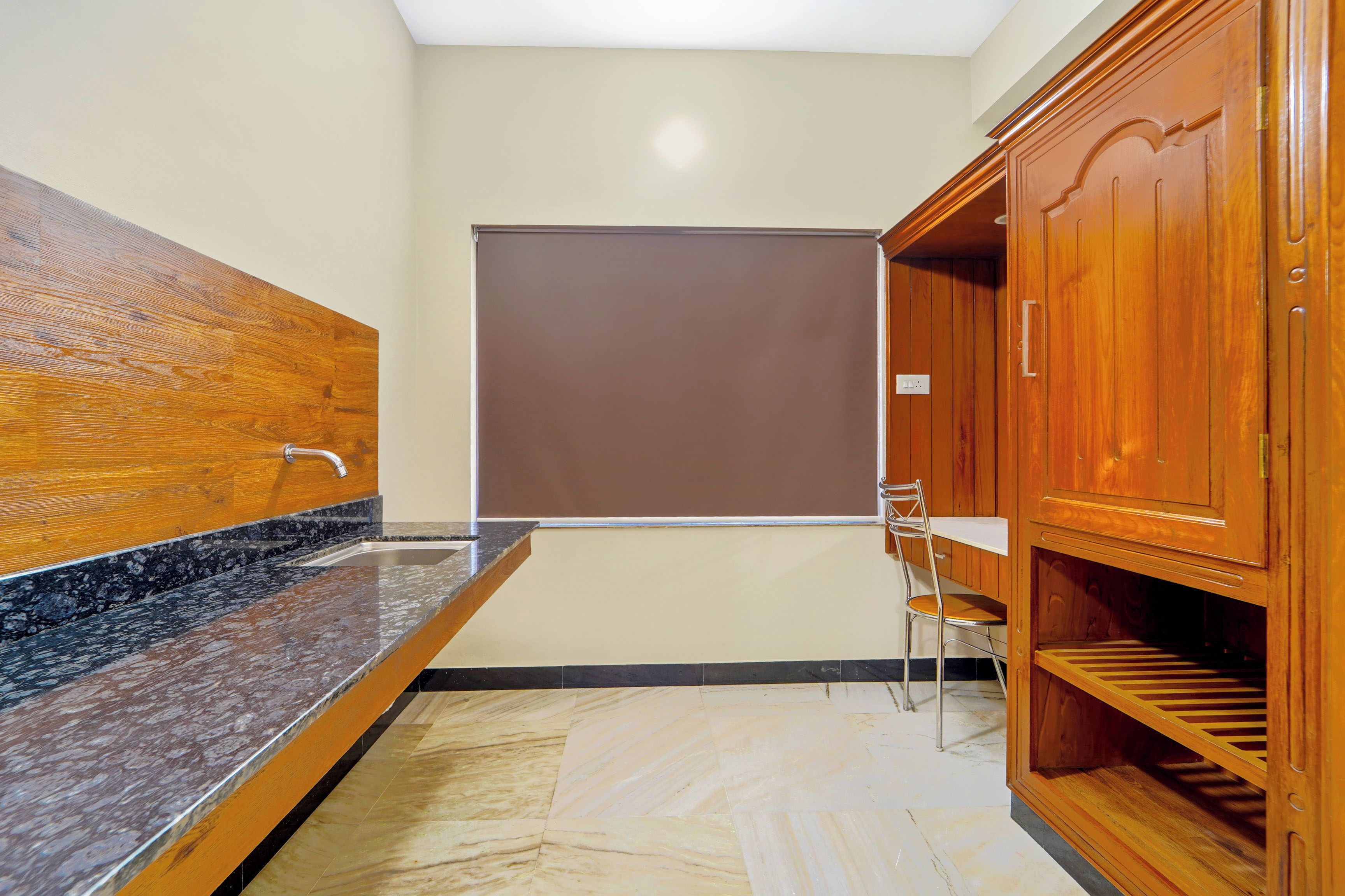 A bathroom with a marble sink, wooden cabinets, and a shower area.