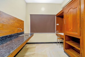 Un baño con lavamanos de mármol, armarios de madera y zona de ducha.