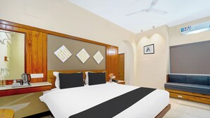 A hotel room with a bed, bedside table, and a large mirror.