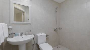 A bathroom with a sink, toilet, and shower.