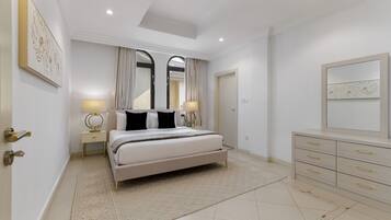 A modern bedroom with a bed, bedside tables, a dresser, and a mirror.