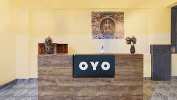 Una recepción con detalles de madera y un letrero que dice 'OYO'.