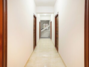 Un pasillo con piso de mármol que conduce a una escalera.