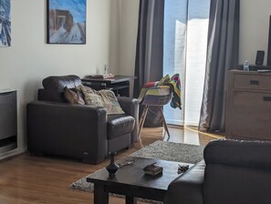 A modern living room with a leather sofa, a small table, and a colorful chair. - Fantastic sunny arty apartment, fully equipped and furnished for short let (Southbank)