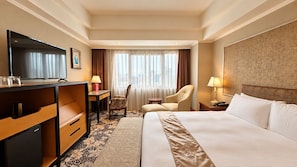 A hotel room with a bed, desk, chair, television, and a view of the city through the window. - BERI HOTEL Kaohsiung (Kaohsiung City)