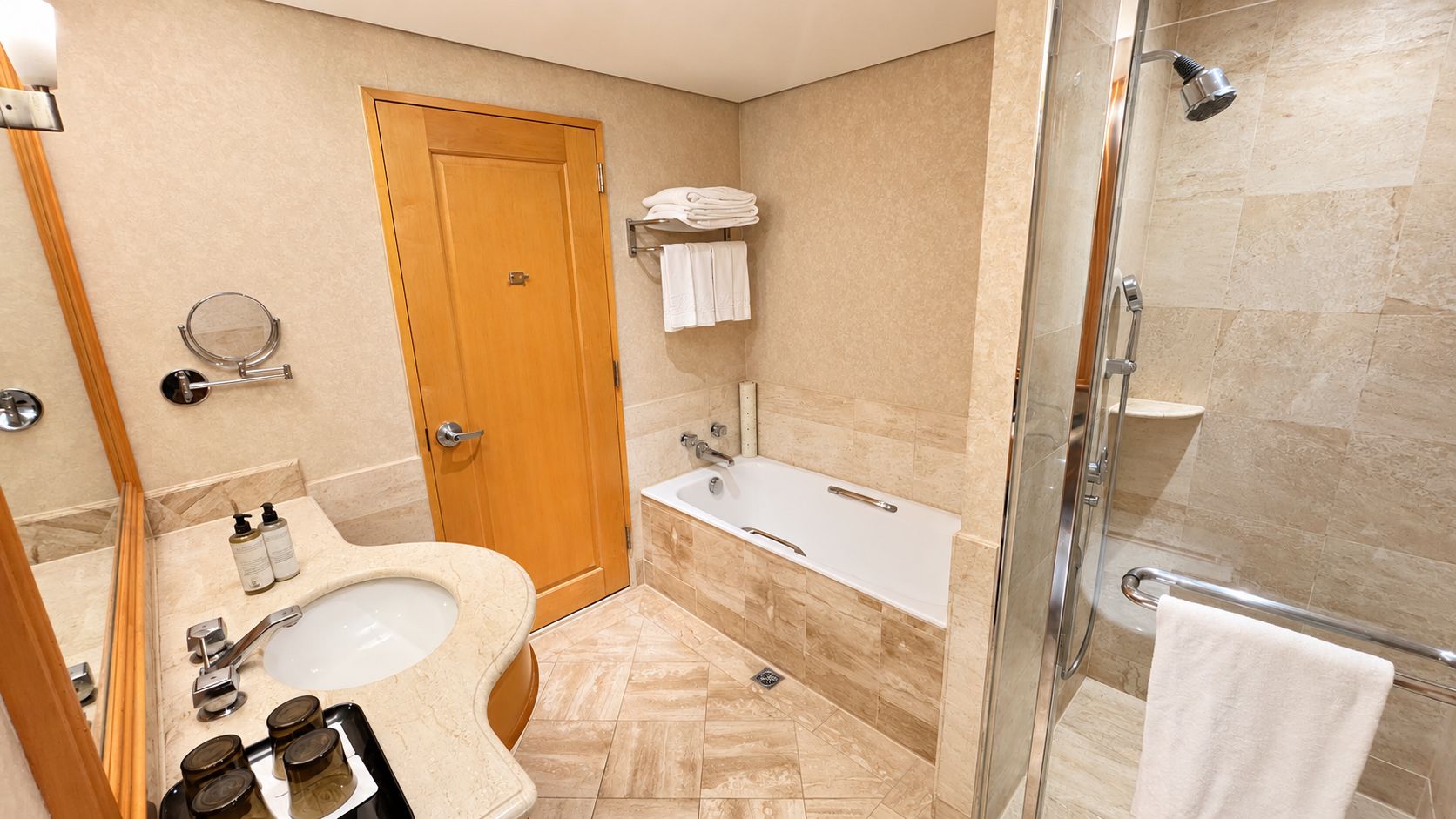 Un bany amb un lavabo, mirall, paraigua i zona de dutxa.