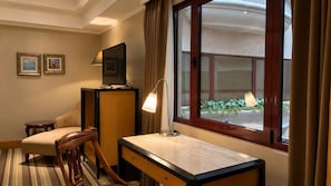 A hotel room with a desk, chair, lamp, and a window with curtains. - BERI HOTEL Kaohsiung (Kaohsiung City)