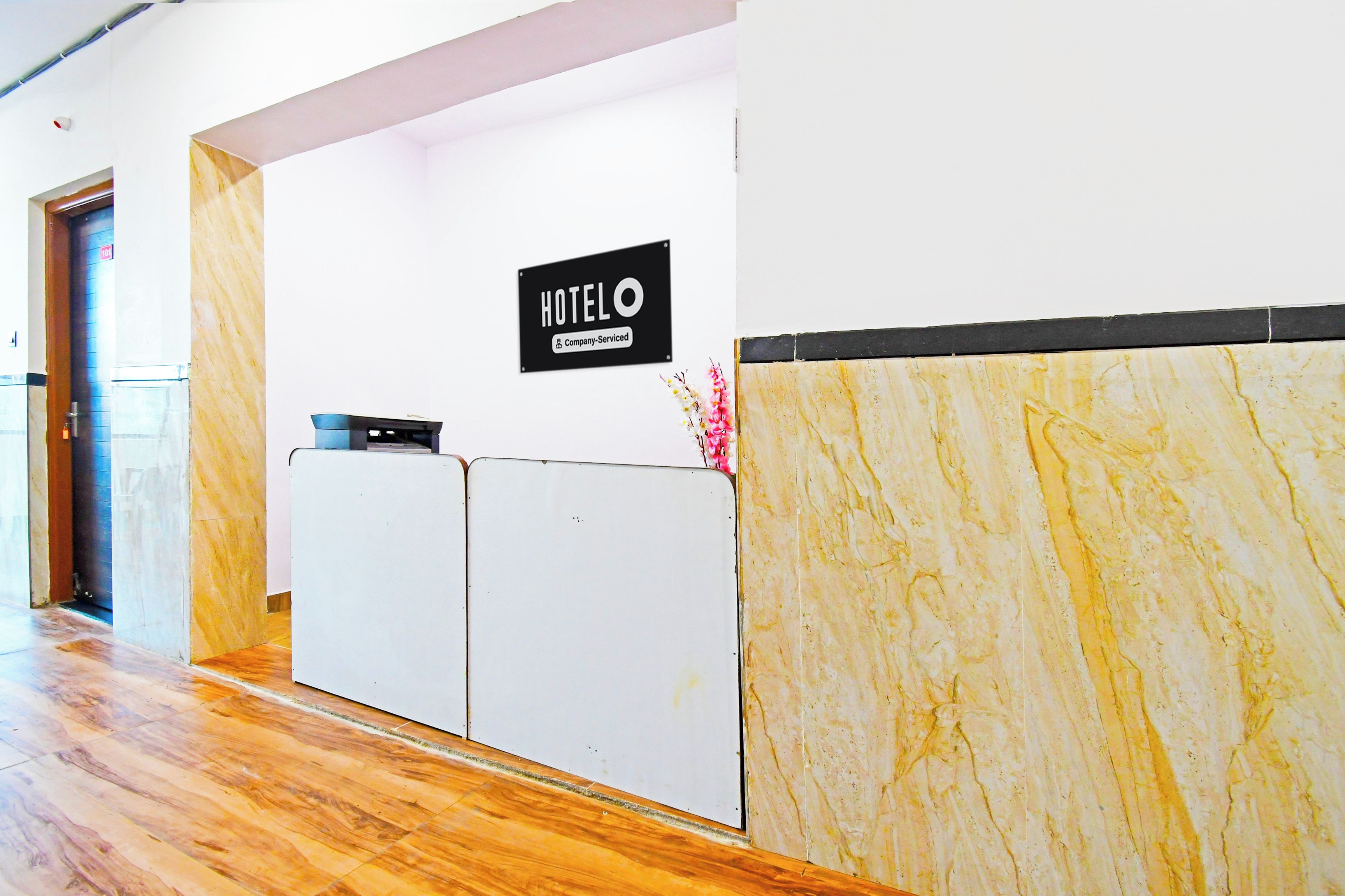 Un comptoir de réception d’hôtel avec une pancarte indiquant qu’il est géré par l’entreprise.