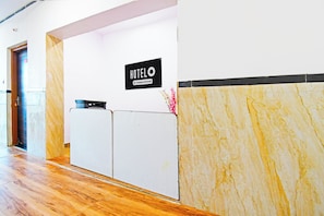 A hotel reception desk with a sign indicating it is company-serviced.