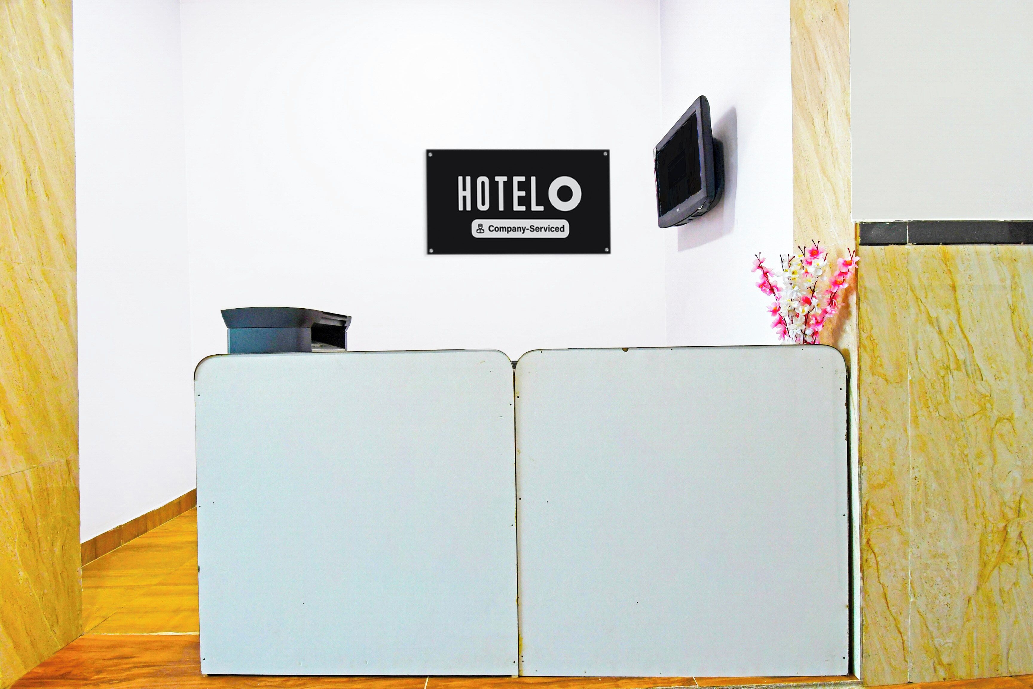 Uma receção com um letreiro a indicar 'HOTEL' e 'Serviços para Empresas'.