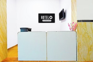 A reception desk with a sign indicating 'HOTEL' and 'Company Serviced.'