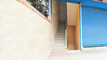 A staircase leading to a closed blue shuttered entrance.
