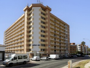 A multi-story hotel with a distinctive corner design, featuring balconies on each floor. - Sunstay Loft Saltillo (Torremolinos)