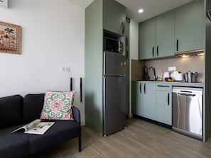 A compact kitchen with a built-in refrigerator, a dishwasher, and a microwave. - Sunstay Loft Saltillo (Torremolinos)