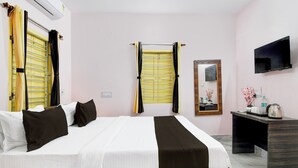 A hotel room with a bed, a desk, a television, and a window with curtains. - Hotel O Ecopark Kolkata (Barasat)