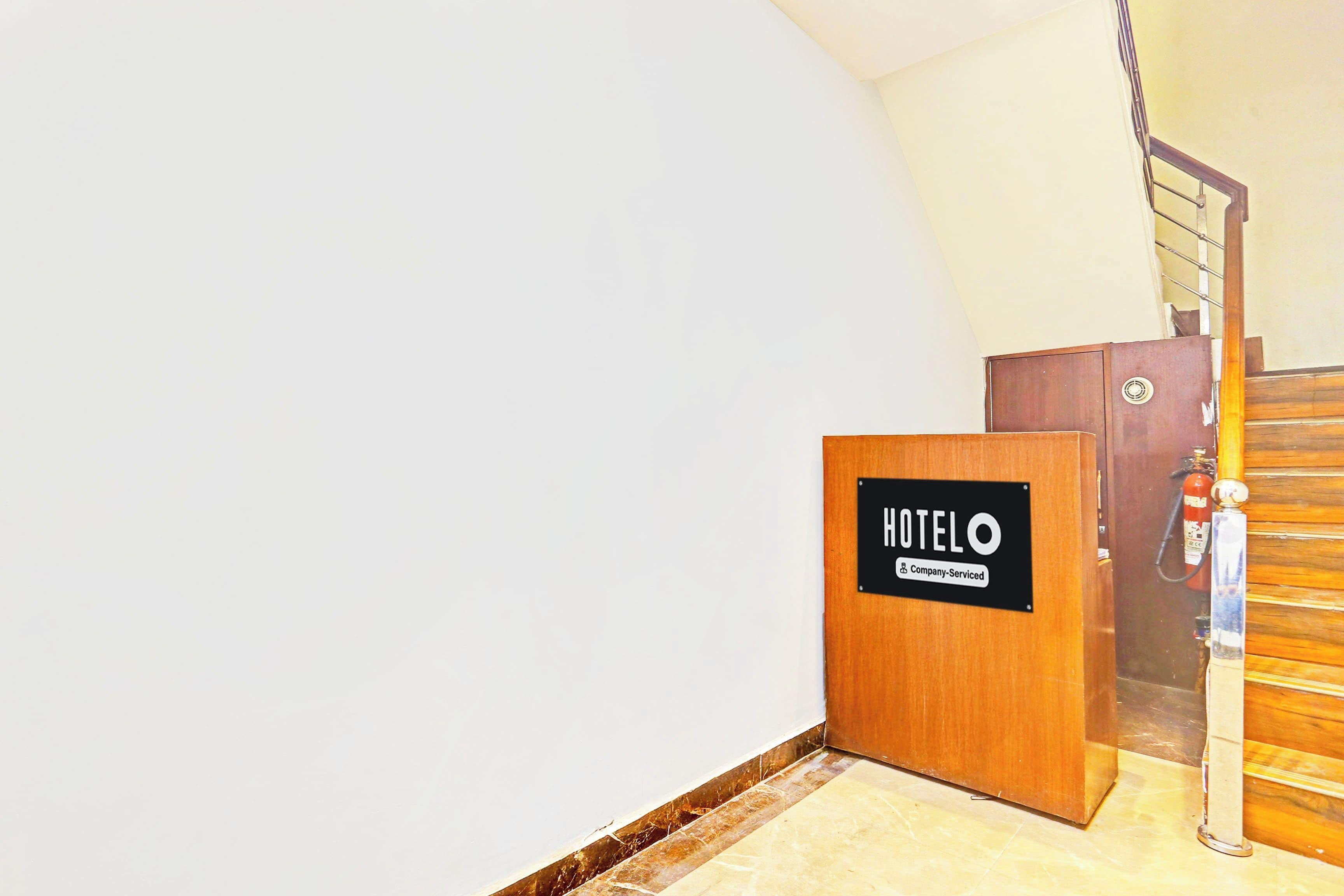 A hotel room entrance with a wooden door labeled 'HOTELO Company Serviced'.