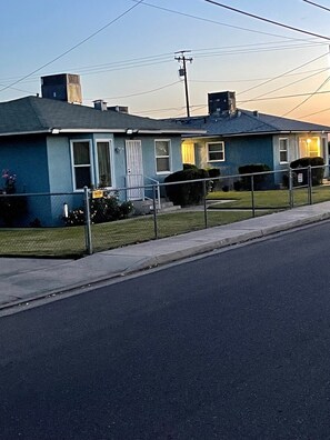 A row of single-story houses with a paved driveway and a sidewalk. - Cozy 1-bedroom apartment in peaceful Fresno with AC (Fresno)