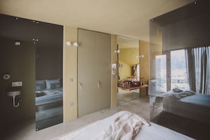 Habitación de hotel moderna con una cama grande, un espejo, un armario y un baño.